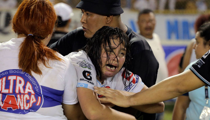 A woman is held by other as she cries following a stampede during a football match between Alianza and FAS at Cuscatlan stadium in San Salvador, on May 20, 2023. — AFP