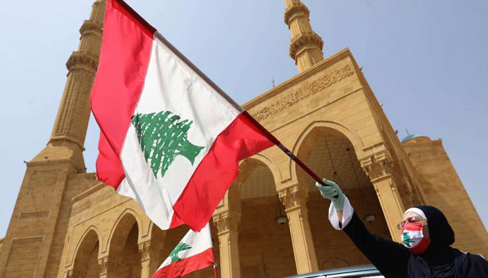 This representational picture shows a Lebanese protester waving the national flag during a rally in front of a mosque in Beirut. — AFP/ File