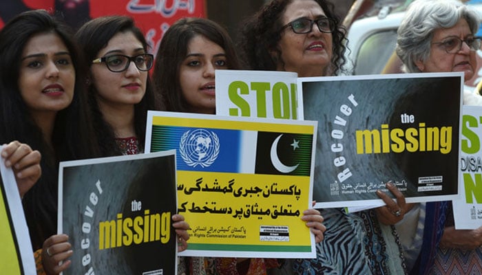 In this file photo, Pakistani human rights activists carry placards during a protest for missing persons to mark the International Day of the Victims of Enforced Disappearances in Lahore. — AFP