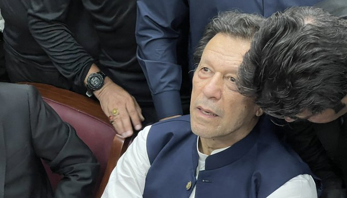 PTI Chairman Imran Khan is pictured while one of his lawyers tells him something during an appearance before IHC. — Twitter/@PTIofficial