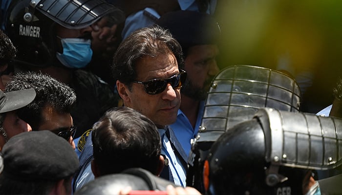 12 Mayıs 2023'te eski başbakan İmran Khan'a (C) İslamabad'daki yüksek mahkemeye varırken polis kammandoları eşlik ediyor. — AFP