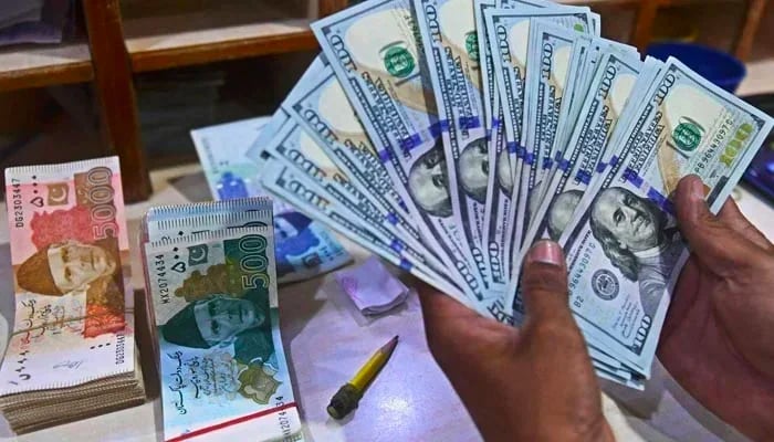 A money exchange employee counts dollars. — AFP/ File