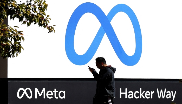 A pedestrian walks in front of a new logo and the name Meta on the sign in front of Facebook headquarters in Menlo Park, California, Oct. 28, 2021. — AFP