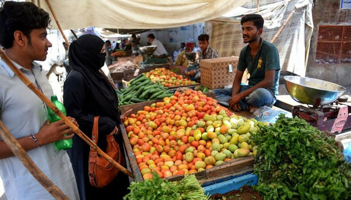 Picture shows people buying vegetables. — AFP/File