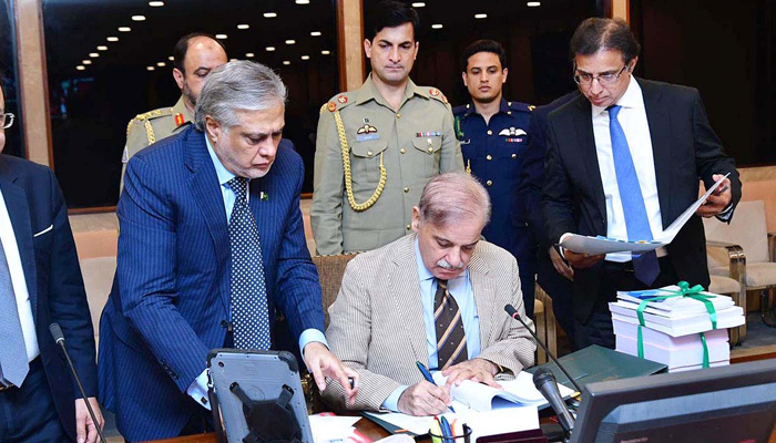 Prime Minister Shehbaz Sharif signs budget 2023-24 documents after its approved by the cabinet to be laid before the National Assembly in Islamabad on June 9, 2023. — APP