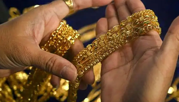 This is a representational image of a person holding gold chains. — AFP/File
