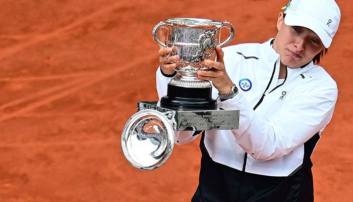 Polands Iga Swiatek looks at the top of the trophy Suzanne Lenglen falling following her victory over Czech Republics Karolina Muchova during their womens singles final match on day fourteen of the Roland-Garros Open tennis tournament at the Court Philippe-Chatrier in Paris on June 10, 2023. AFP