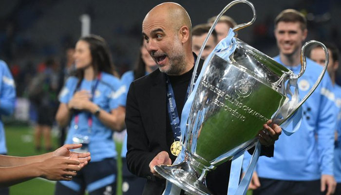 Pep Guardiola, the manager of Manchester City expressing joy holding the trophy after the club won Champions League final. Twitter