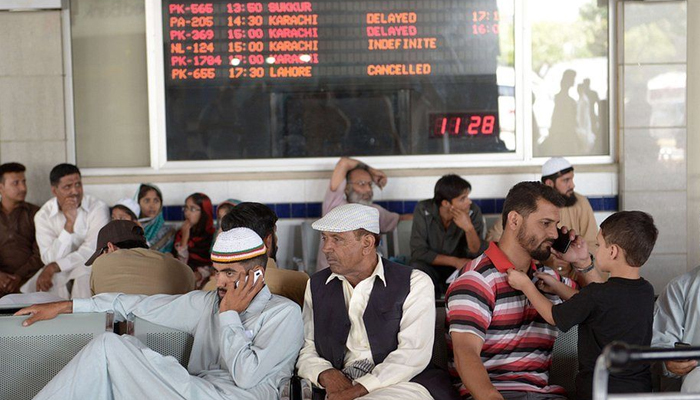 Passengers wait ahead of boarding their flight at the Jinnah International Airport in Karachi. — AFP/File