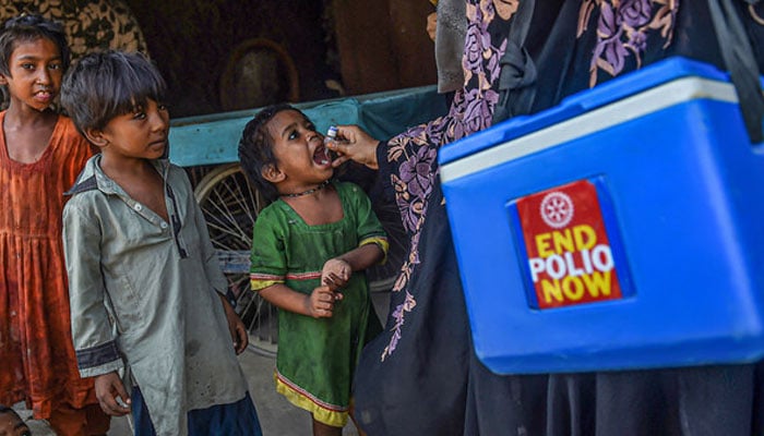 A health worker administers polio vaccine drops to a child during a vaccination campaign in Karachi, Pakistan, on October 24, 2022. — AFP