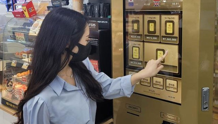 This picture shows a woman using a gold bar vending machine. — GS Retail/File