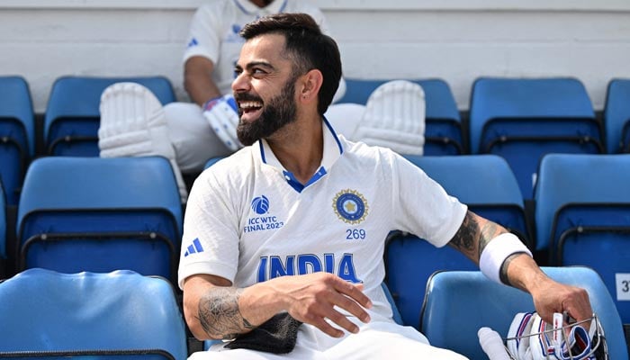 Indias Virat Kohli (FRONT) shares a light moment with teammate Indias Ajinkya Rahane (REAR) as they prepare to walk out to bat ahead of play on day 5 of the ICC World Test Championship cricket final match between Australia and India at The Oval, in London, on June 11, 2023. — AFP