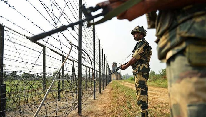 Indian soldiers stand alongside a barbed wire on the Line of Control. — AFP/File
