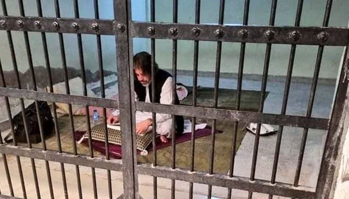 PTI leader Ali Muhammad Khan is reading a book in the custody. — Twitter/@Obibhatti/File