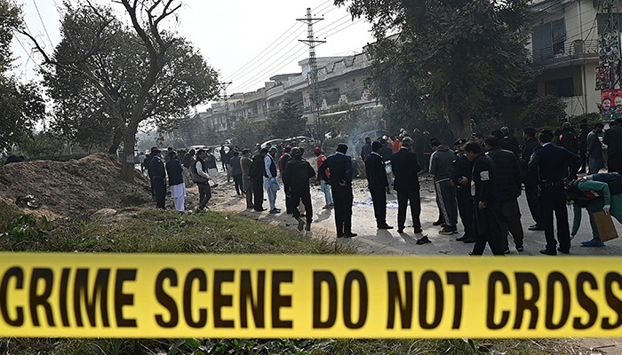 Policemen gather at the suicide blast site in Islamabad on December 23, 2022. — AFP