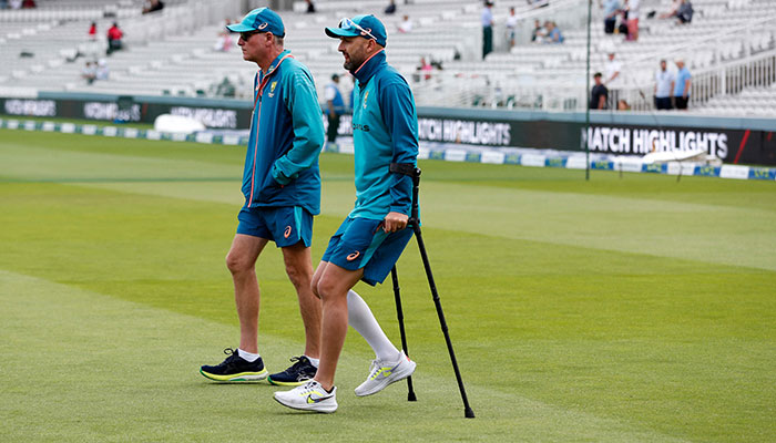 Australia´s Nathan Lyon uses crutches to walk onto the pitch ahead of play on day five of the second Ashes cricket Test match between England and Australia at Lord´s cricket ground in London on July 2, 2023.