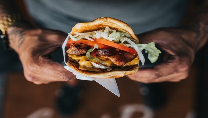 This representational picture shows a man holding a loaded sandwich. — Unsplash/File