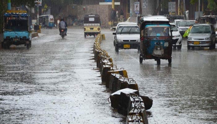 Vehicles passing through rainwater during the heavy rain in Karachi on March 24, 2023. — INP