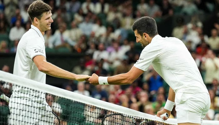 Novak Djokovic shakes hands with Hubert Hurkacz as their fourth-round match at Wimbledon is suspended as it approaches the curfew.—Getty Images