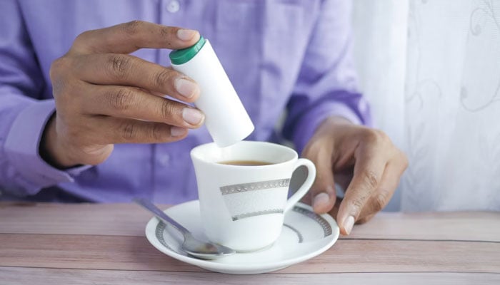 This representational picture shows a man adding artificial sweetener (Aspartame) to his tea. — Unsplash/File