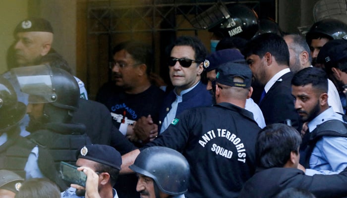 Security officers escort former prime minister Imran Khan as he appeared in the Islamabad High Court on May 12, 2023. —Reuters