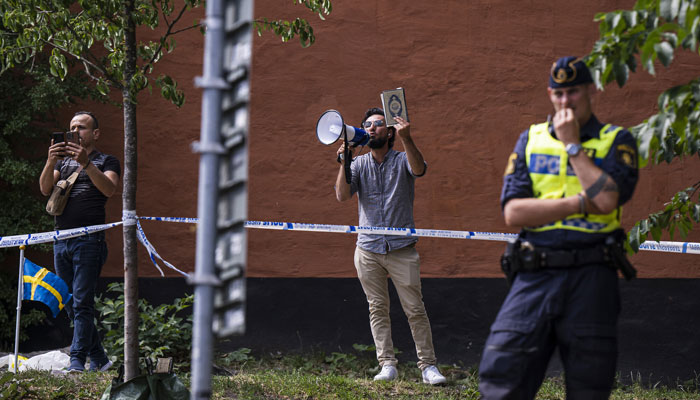 Salwan Momika holds a Quran as he protests outside a mosque in Stockholm on June 28, 2023, during the Eid al-Adha holiday. — AFP/File