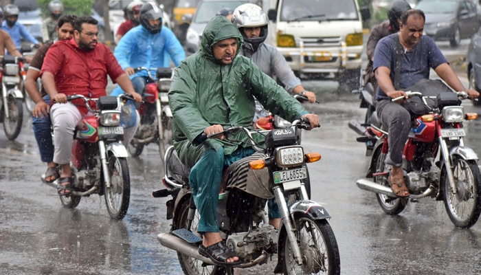 Motorists on their way during heavy rain fall in Lahore on July 15, 2023. — Online