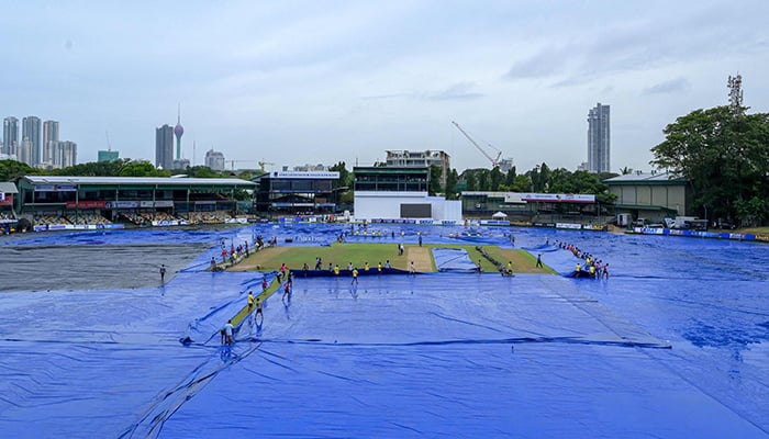 Ground staff uncover the pitch after rain delayed the start of the first day of the final cricket Test match between Pakistan and Sri Lanka at the Sinhalese Sports Club (SSC) Ground in Colombo on July 24, 2023. — AFP