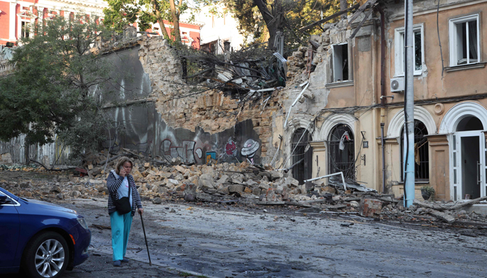 A woman walks past buildings damaged as a result of a missile strike in Odesa on July 23, 2023. — AFP