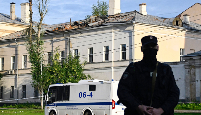 Police secure an area outside a damaged non-residential building on Komsomolsky Prospekt after a reported drone attack in Moscow on July 24, 2023. — AFP