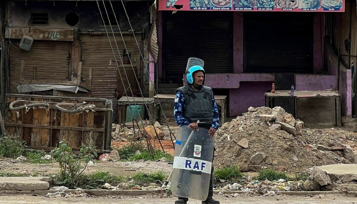 A law enforcement personnel stands beside closed shops following communal clashes in Nuh in India’s Haryana on August 2, 2023. — AFP