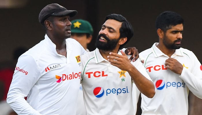 Sri Lanka´s Angelo Mathews (L) speaks with Pakistan´s Fawad Alam (C) before the start of third day of the second cricket Test match between Sri Lanka and Pakistan at the Galle International Cricket Stadium in Galle on July 26, 2022. — AFP