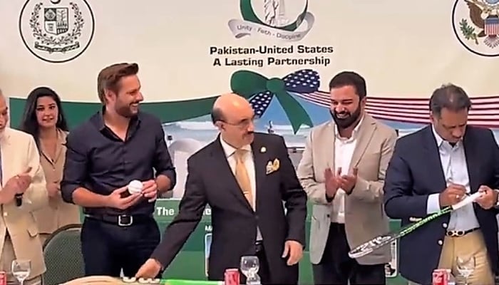 In this still taken from a video Shahid Afridi (left) and Jahangir Khan (right) sign souvenirs. — Twitter/@PakinUS