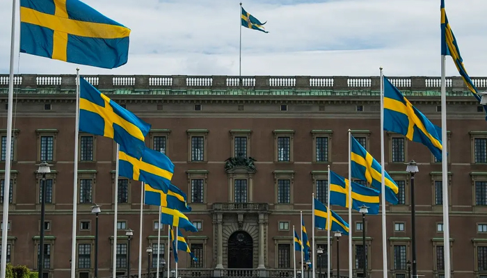 Swedish flags fly in front of the Royal Palace in Stockholm on May 29, 2020. — AFP
