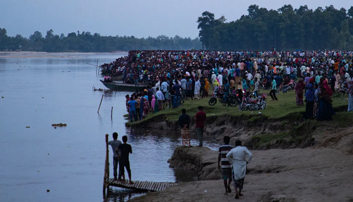 People gather along the riverbank after a boat capsized near the town of Boda on September 25, 2022. CNN