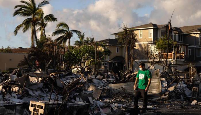 Mercy Worldwide gönüllüsü, 12 Ağustos 2023'te Hawaii, batı Maui, Lahaina'da çıkan bir orman yangınının ardından yanmış bir apartman kompleksinin hasar tespitini yapıyor. — AFP