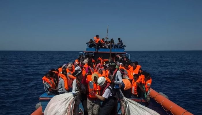 Migrants can be seen sitting in a boat. — AFP/File
