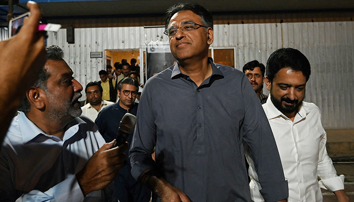 PTI leader Asad Umar (centre) leaves after announcing to step down from his party position in Islamabad on May 24, 2023. — AFP