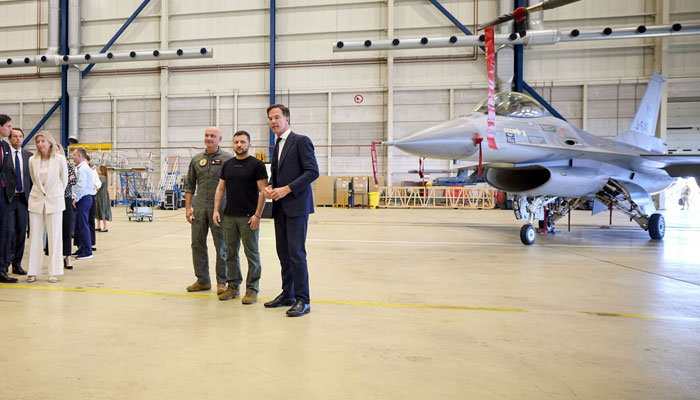 This photograph taken and released by the Ukrainian Presidential Press Service on August 20, 2023, shows Ukraine´s President Volodymyr Zelensky (2nd-R) and Dutch Prime Minister Mark Rutte (R) standing next to an F-16 fighter jet in the hangar at the Eindhoven Military Air Base in Eindhoven.—AFP