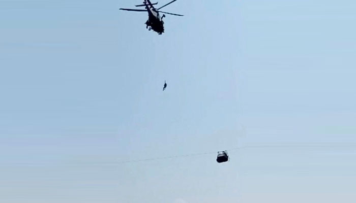 An army soldier slings down from a helicopter during the rescue mission to recover students stuck in a cable car in Pashto village of mountainous Khyber Pakhtunkhwa province, on August 22, 2023. — AFP