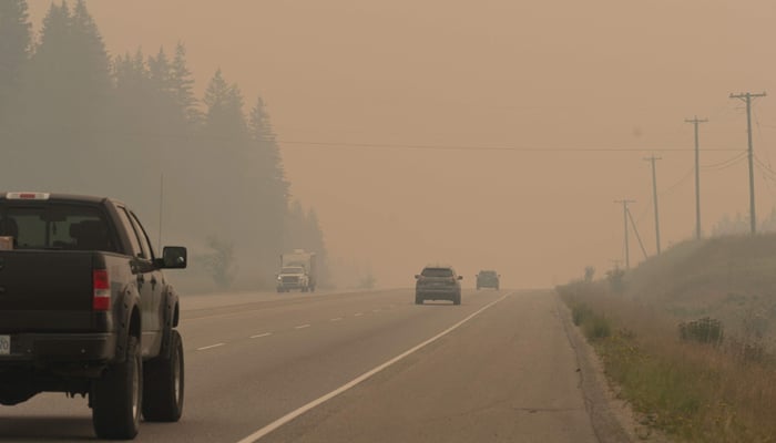 Traffic on Hwy 1 drives through heavy wildfire smoke from the nearby Bush Creek East Wildfire in Sorrento, British Columbia, on August 20, 2023. — AFP