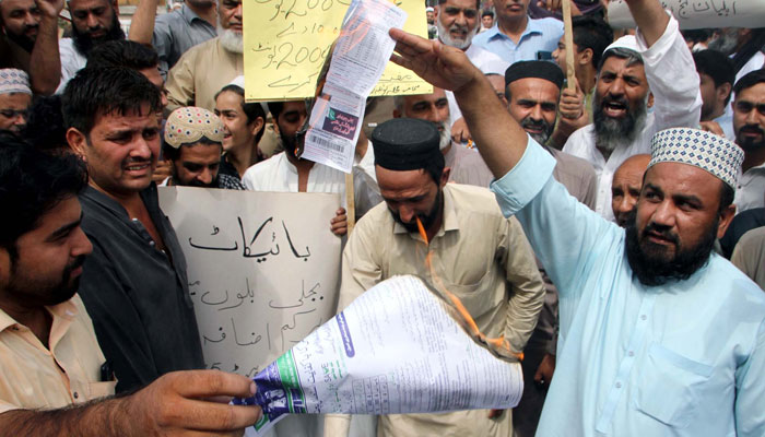 Citizens burn electricity bills as they are holding protest demonstration against the highly inflated electricity bills, held at Gunj Chowk in Peshawar on Saturday, August 26, 2023. — PPI