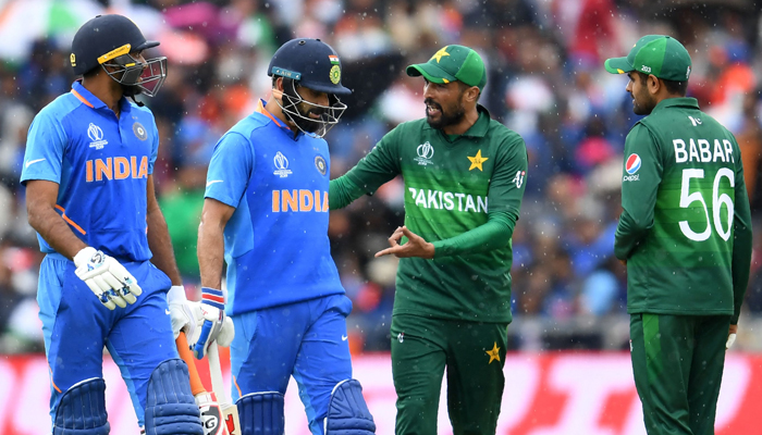 Mohammad Amir (2R) ve takım arkadaşı Babar Azam (sağda), Hindistan arasındaki 2019 Kriket Dünya Kupası grup aşaması maçında yağmurun durması nedeniyle pavyona geri dönerken Hindistan'ın kaptanı Virat Kohli (C) ve Hindistan'dan Vijay Shankar (L) ile konuşuyor ve Pakistan, İngiltere'nin kuzeybatısındaki Manchester'daki Old Trafford'da.  — AFP