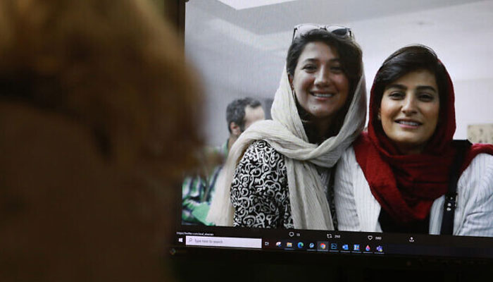 A woman looks at a picture of Iranian reporters Niloufar Hamedi (left) and Elahe Mohammadi posted on Twitter, in Nicosia on November 2, 2022. —AFP