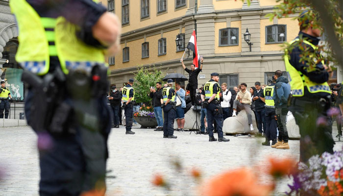 Policemen stand next to demonstrators at Mynttorget Square in Stockholm, Sweden, July 31, 2023. —AFP