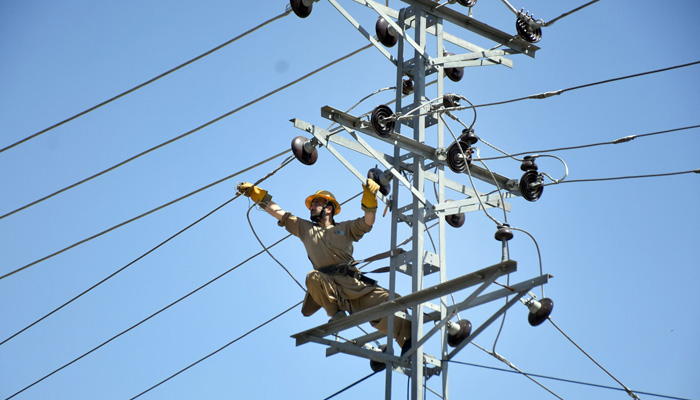 A WAPDA worker fixes electricity wires on a pole in Islamabad on August 4, 2023. — Online