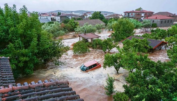 This general view shows a car and houses in a flooded area in Volos, Greece on September 5, 2023. — AFP
