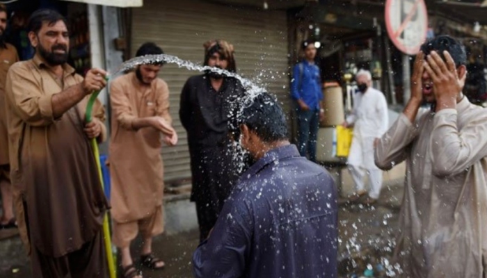 People spray each-other with water during a hot streak in Karachi, Pakistan — AFP/Files
