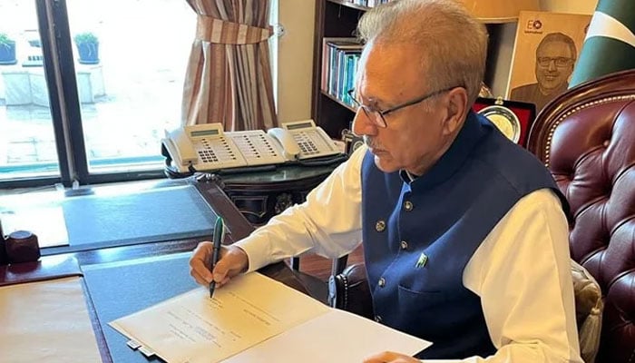 President Alvi signs the appointment of PM Kakar. — Twitter/@PresOfPakistan