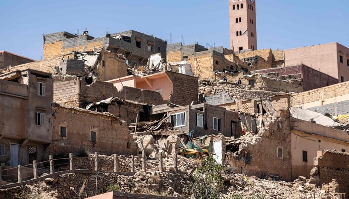 The minaret of a mosque stands behind damaged or destroyed houses following an earthquake in Moulay Brahim, Al-Haouz province, on September 9, 2023. — AFP
